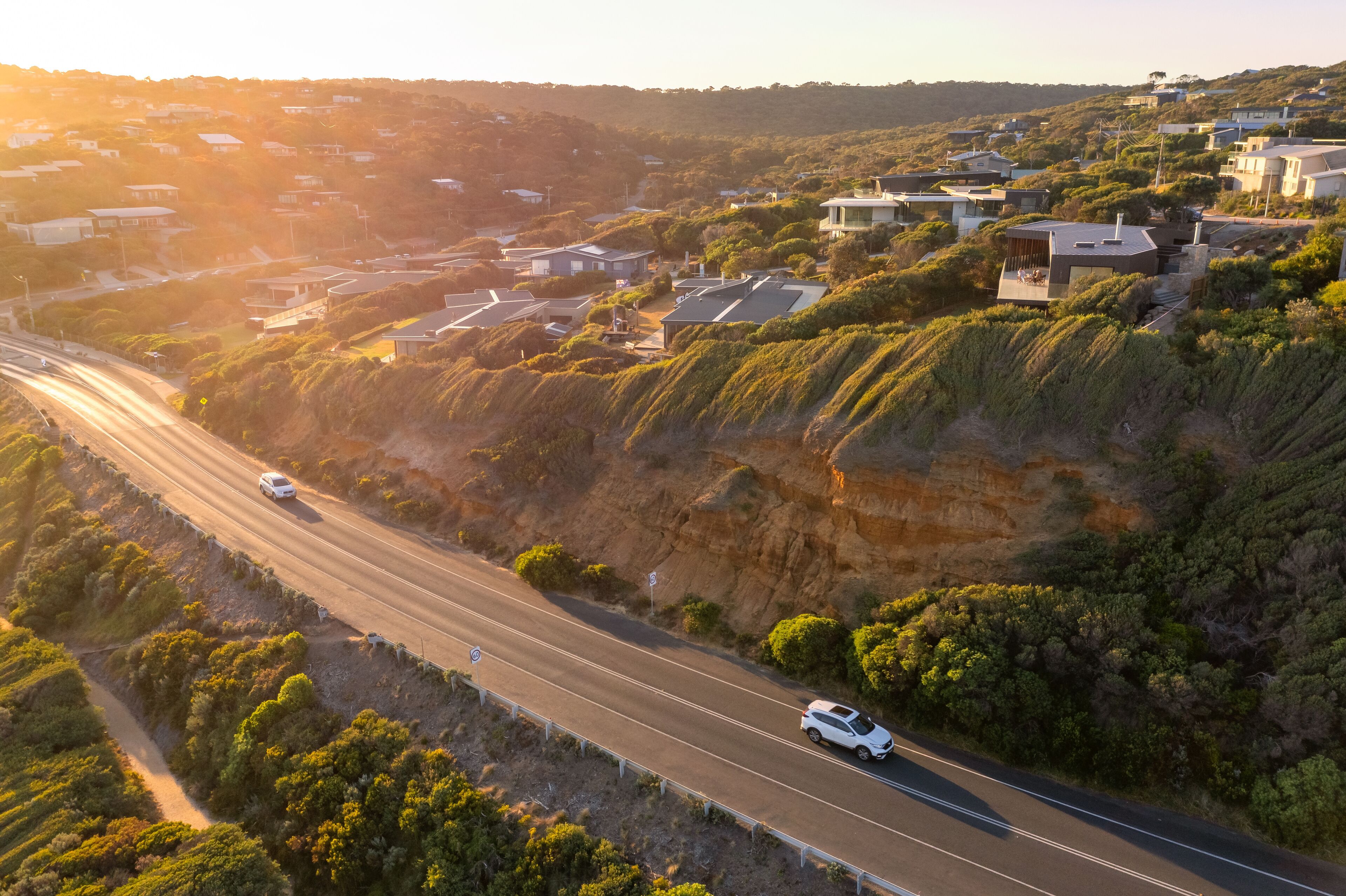 Aerial view of traffic on a high coastal road in late afternoon sunshine