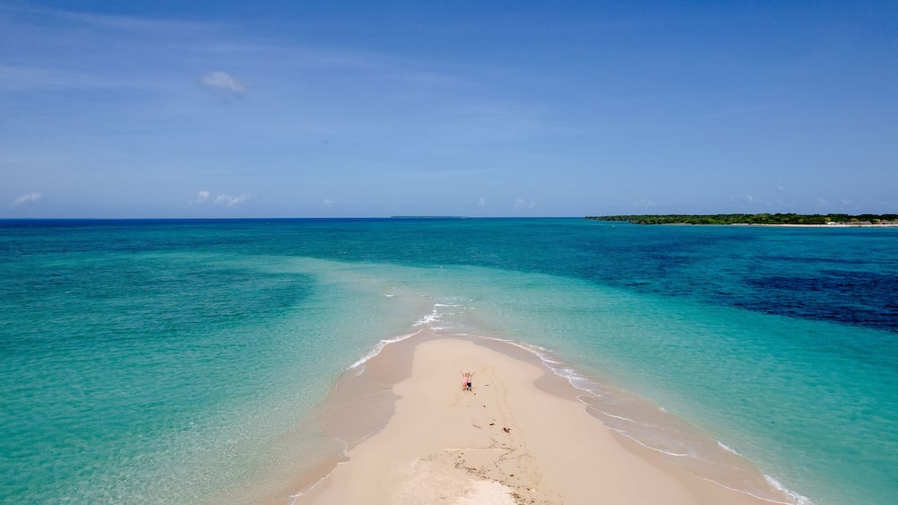 A beach with clear turquoise waters and a sandy shore.