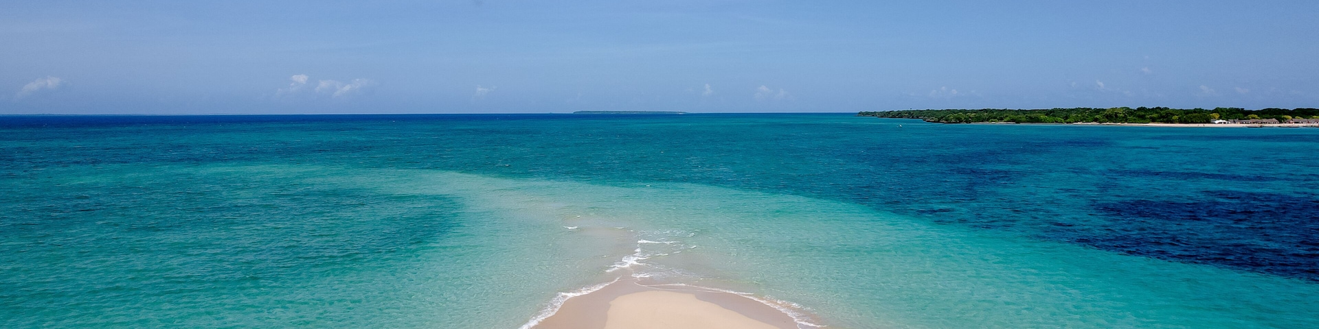 Una playa con aguas turquesas cristalinas y una orilla de arena.