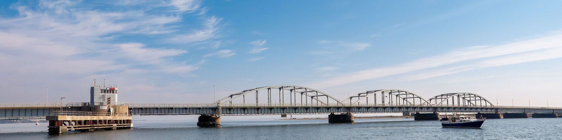 A bridge over a river with a boat in the foreground.