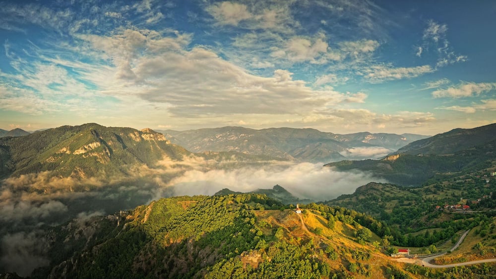 Landscape from Rhodope mountains in Bulgaria during sunset or sunrise. Small chapel and monastery near Borovo, Rhodopes.
