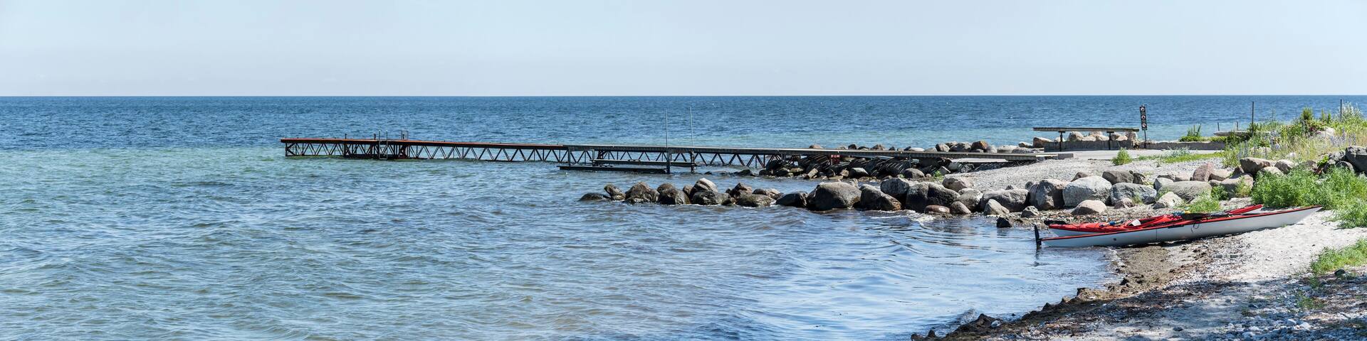 kayaks and pier on Koge bay shore, Stroby Egede, Denmark