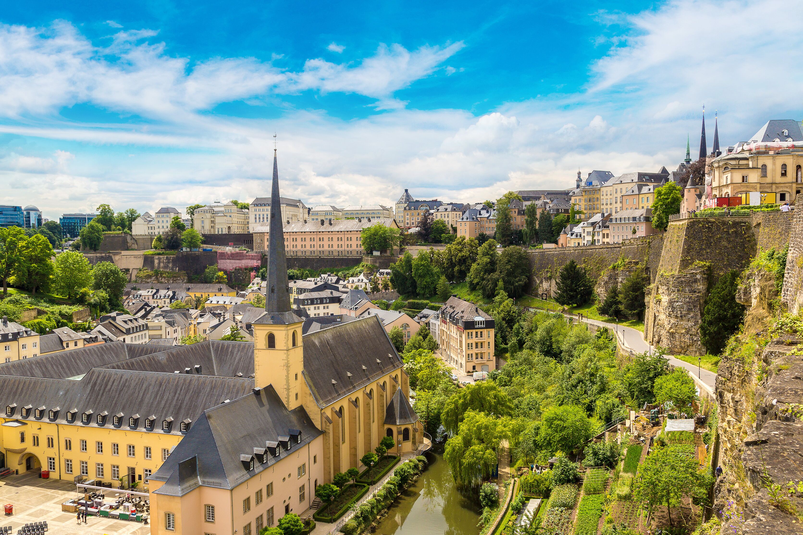 A historic town with a prominent church, a river, and a castle on a hill.