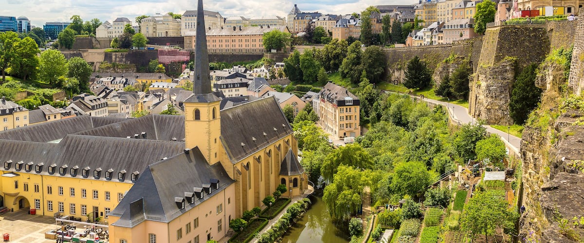 A historic town with a prominent church, a river, and a castle on a hill.