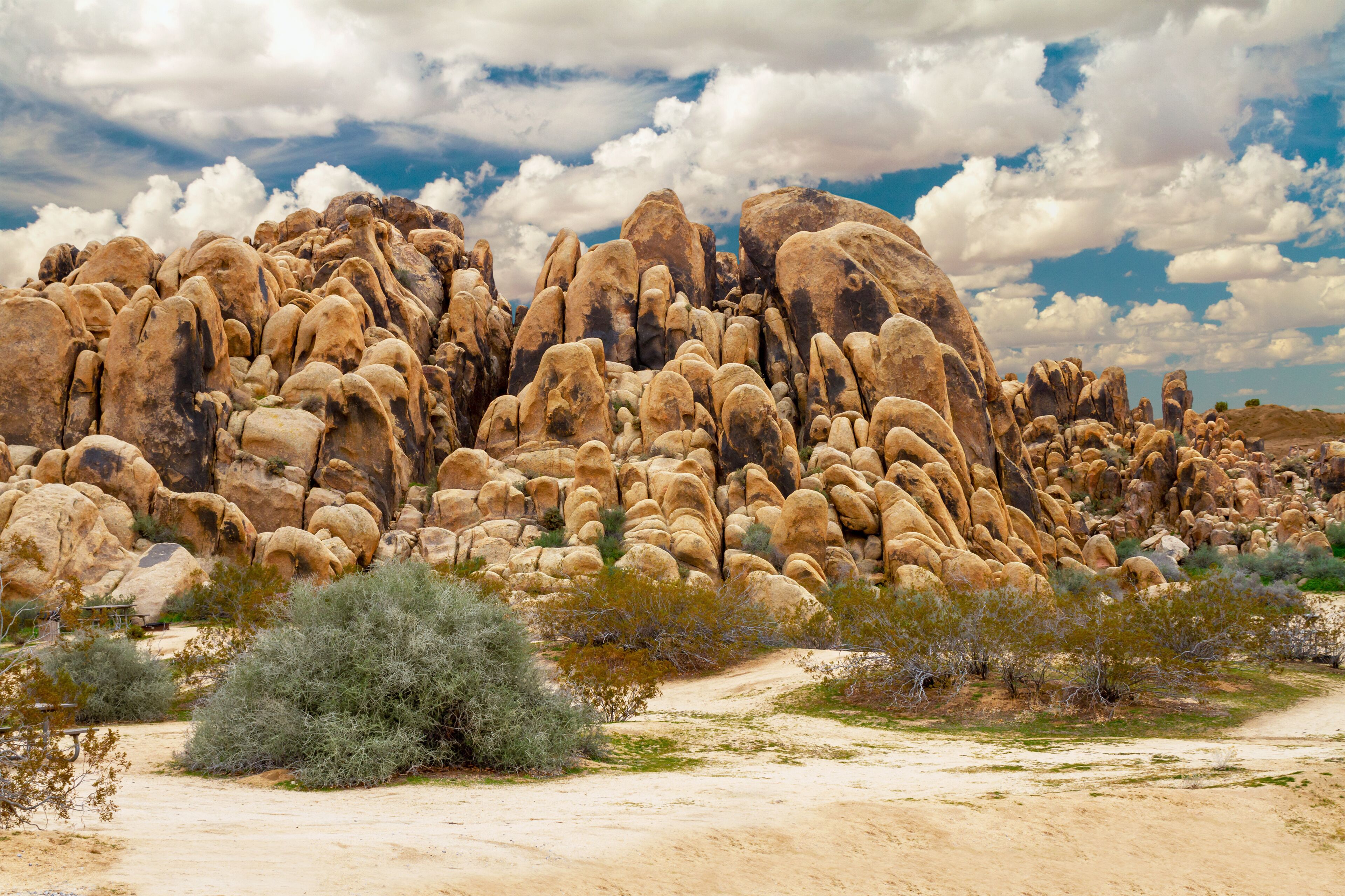 A desert landscape with prominent rock formations and sparse vegetation.