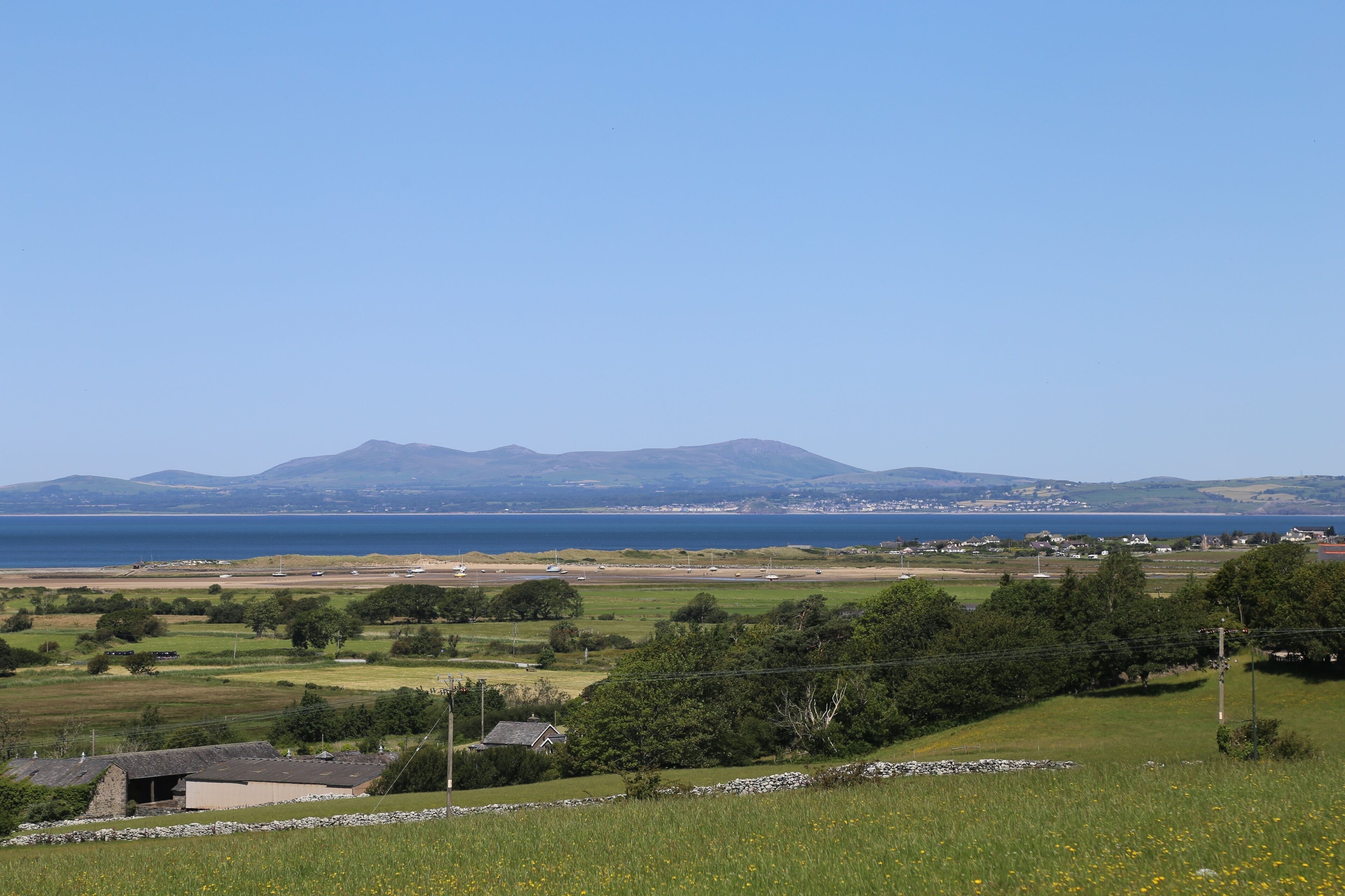 A view across farmland towards the Llyn Peninsula and Cardigan Bay from Llanbedr, Wales, UK.