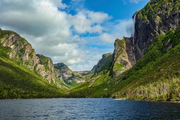 A fjord surrounded by steep cliffs and lush greenery.