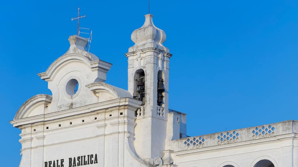 A white church with the inscription "REALE BASILICA" and a bell tower.