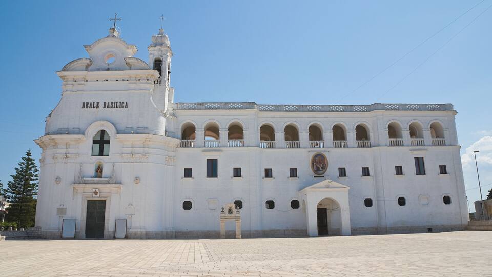 A large white building with arched windows and a bell tower, labeled "Reale Basilica."