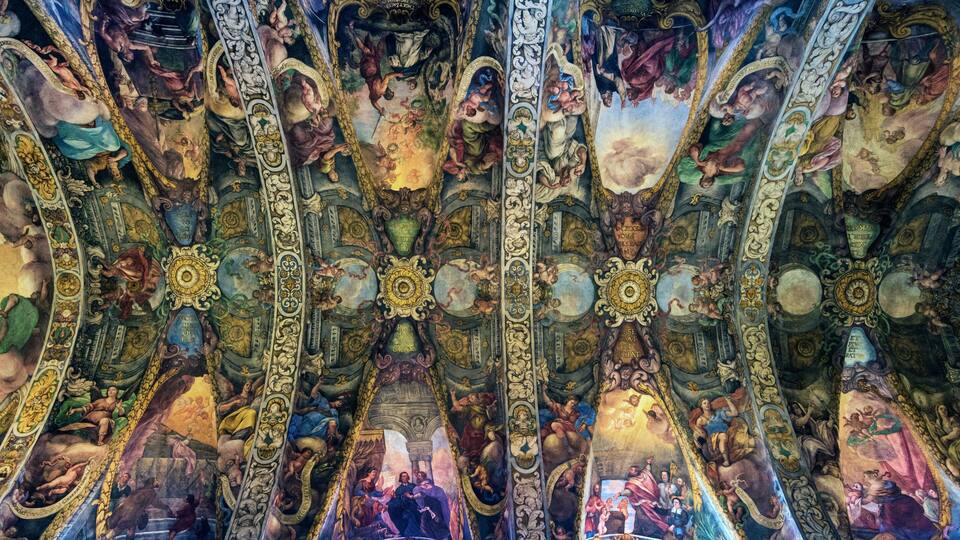 A detailed ceiling fresco with intricate artwork and architectural elements.
