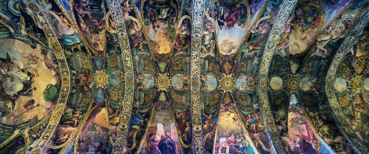 A detailed ceiling fresco with intricate artwork and architectural elements.