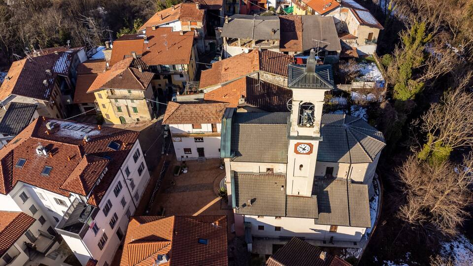 A cluster of buildings with red-tiled roofs and a prominent clock tower.