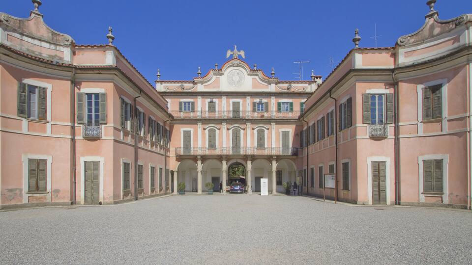 A historic building with a symmetrical facade, arched windows, and a central entrance.