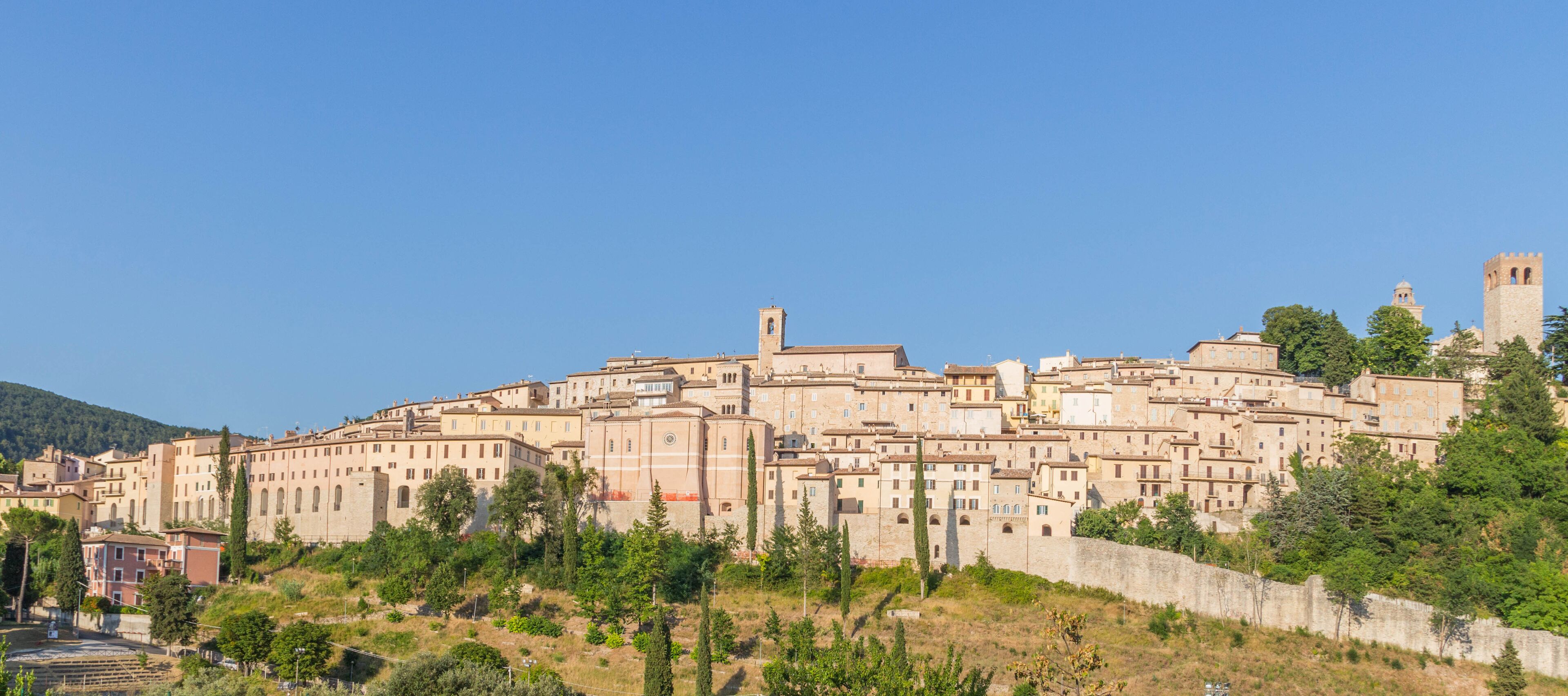 A historic town with medieval architecture, including towers and a fortified wall.