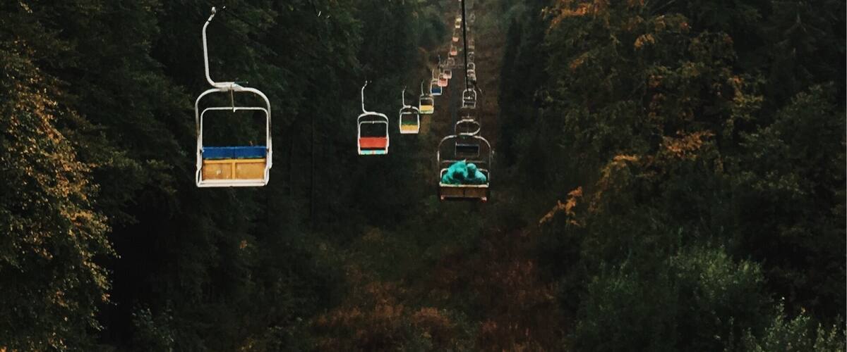 A cable car system in a forested area with mist.