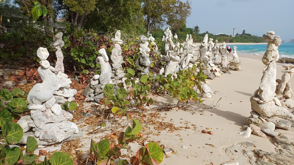 A beach with unique rock formations and a clear view of the ocean.