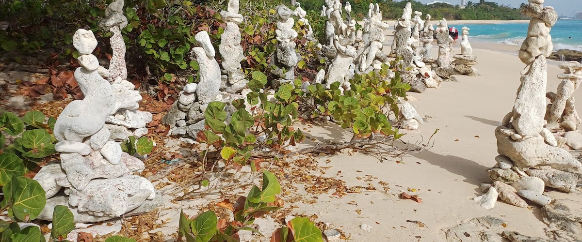 A beach with unique rock formations and a clear view of the ocean.