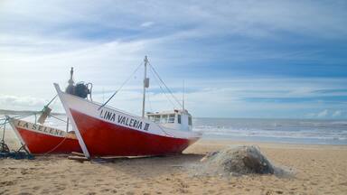 Um barco vermelho e branco chamado 'LINA VALERIA III' numa praia de areia, com o oceano ao fundo.