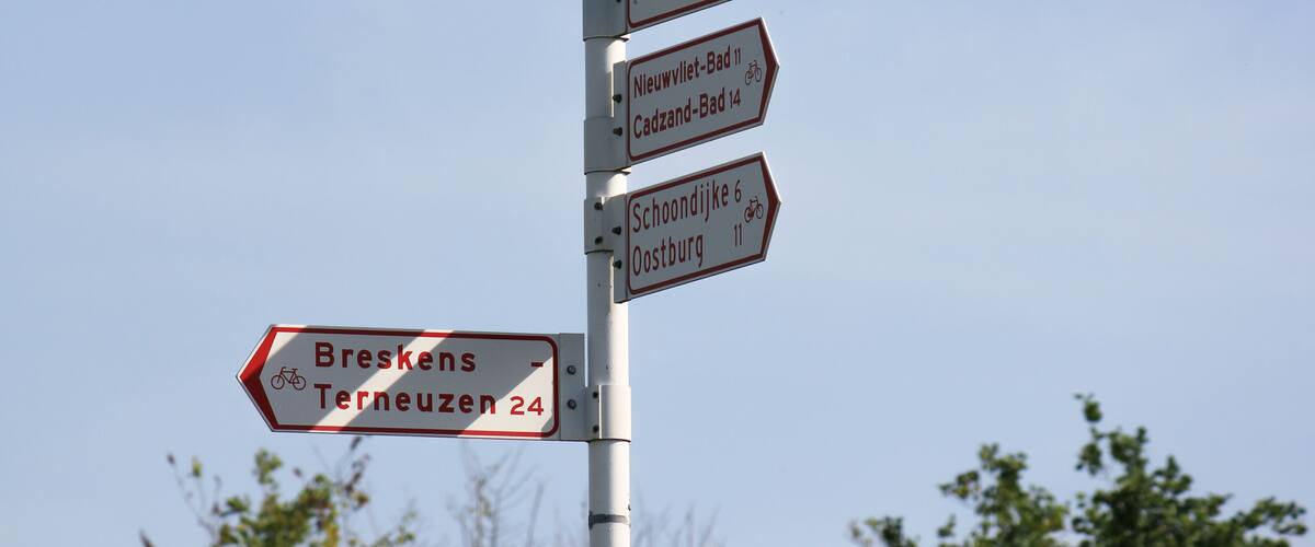 A directional signpost with multiple arrows pointing to various destinations.