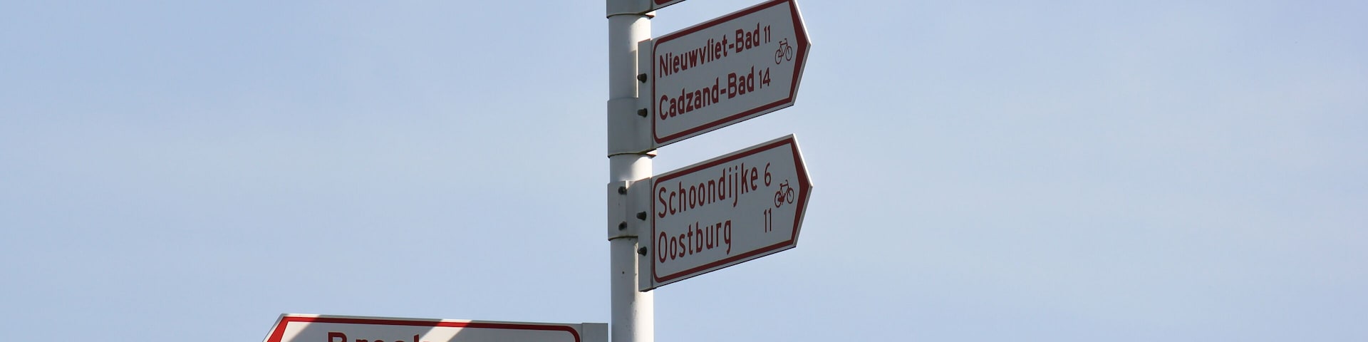 A directional signpost with multiple arrows pointing to various destinations.
