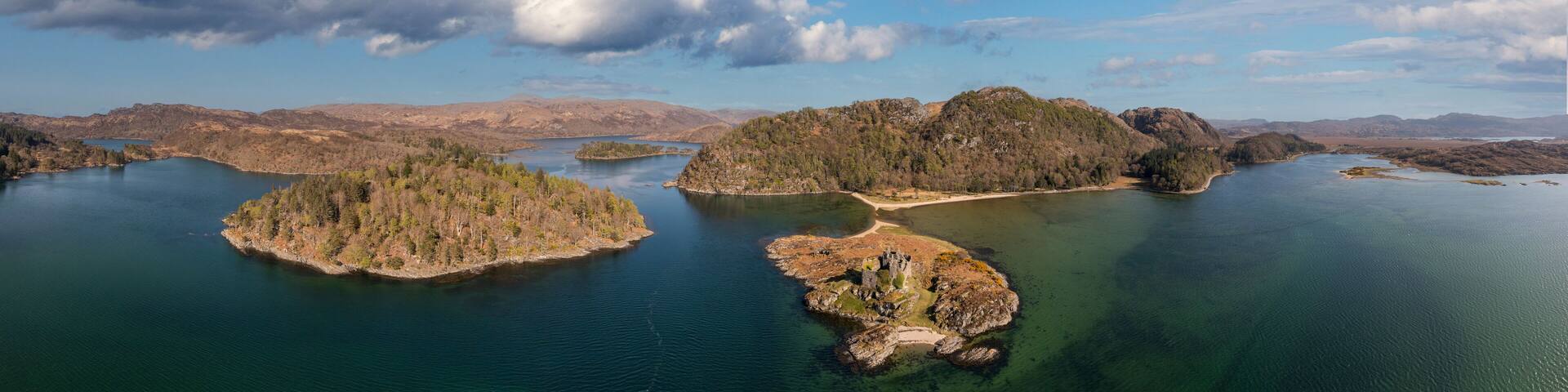 Aerial view of the picturesque Castle Tioram surrounded by tranquil waters and scenic islands, Acharacle, United Kingdom.