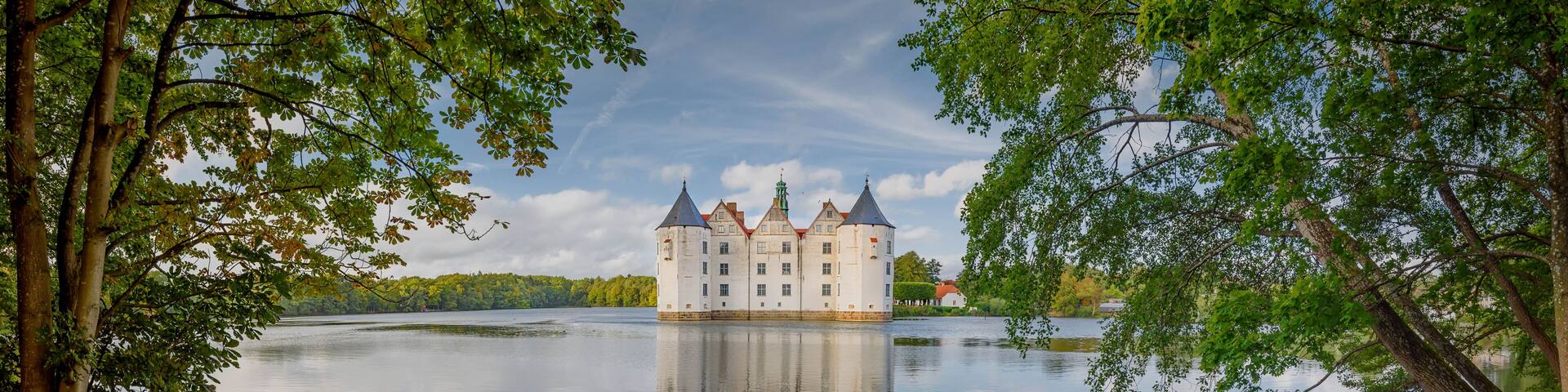 View of water castle Glücksburg on the Flensburg Fjord in the town of Glücksburg, Schleswig-Holstein, Germany. Renaissance castle on the lake in Glucksburg.