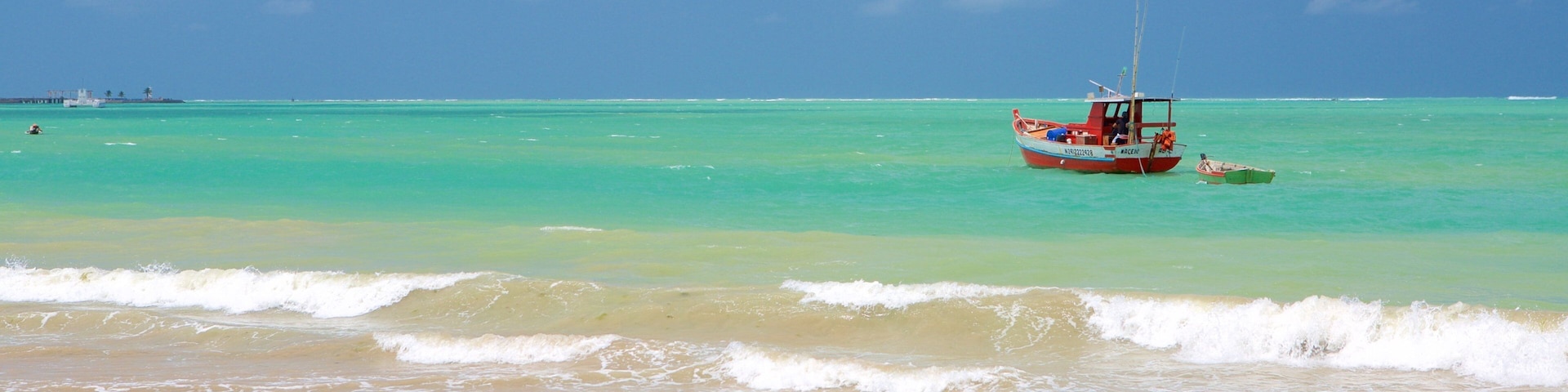 Playa de Pajuçara mostrando una playa de arena, botes y pesca