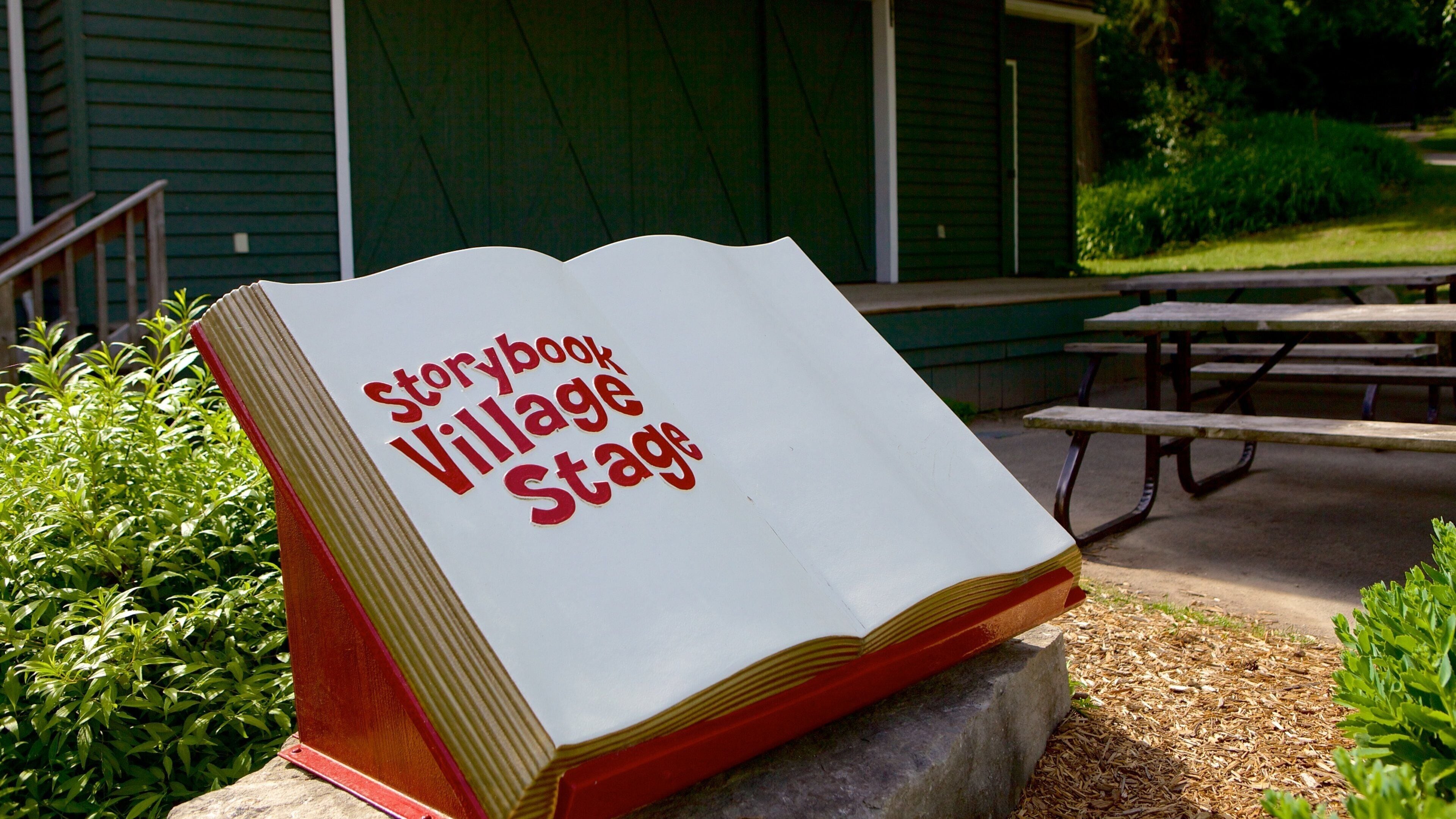 Um letreiro em formato de livro com a inscrição 'Storybook Village Stage'.