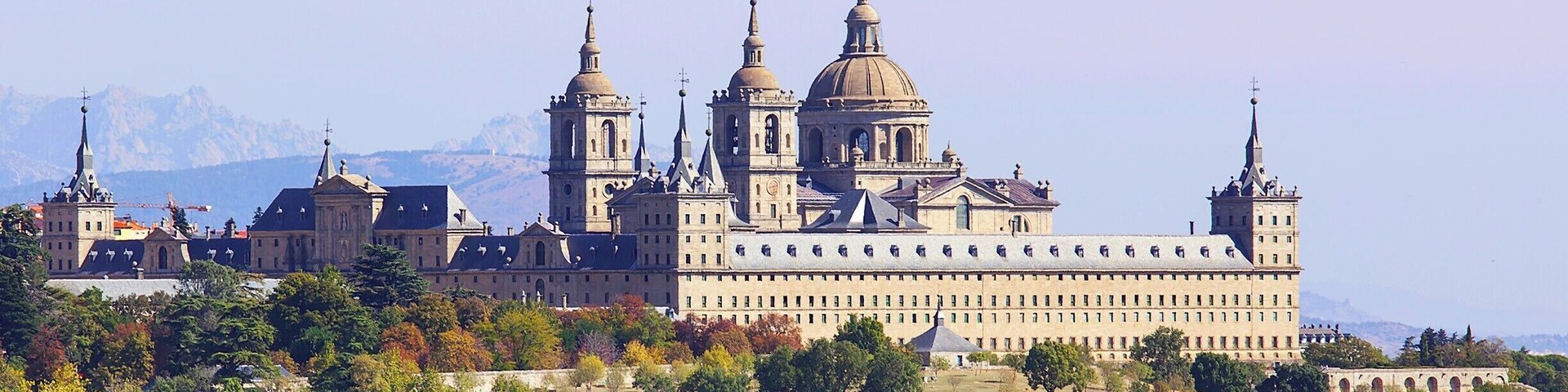 El Escorial was built by King Philip II in the late 16th century to serve as both a royal palace and as the seat of the Catholic Church in Spain. In addition to the palace the complex includes a basilica, a convent, a school, a library, and a pantheon.
While El Escorial is impressive from the outside, we actually found it a little austere on the inside. In many ways it felt more like a fine art museum than a typically elaborate European palace (such as Versailles). That said, there are some impressive sights, including works by El Greco, Bernini, and Giardini. The library was also quite beautiful, with richly carved wood shelves, a marble floor, and a colorful fresco ceiling by Pellegrino Tibaldi.
For me, the highlight of the tour was the 180ft long (55m) Hall of Battles – a barrel-vaulted room where the walls were completely covered in frescos depicting Spain's military victories over the Moors and the French. All aspects of the battle field were portrayed (when you have 180ft, that is quite doable), and the artist employed an interesting trick whereby the more distant, smaller scenes were less saturated, and the background mountains and landscape were set in hues of blue.
Overall I'd say El Escorial is worth a visit, but you probably won't need more than a couple of hours to enjoy it.