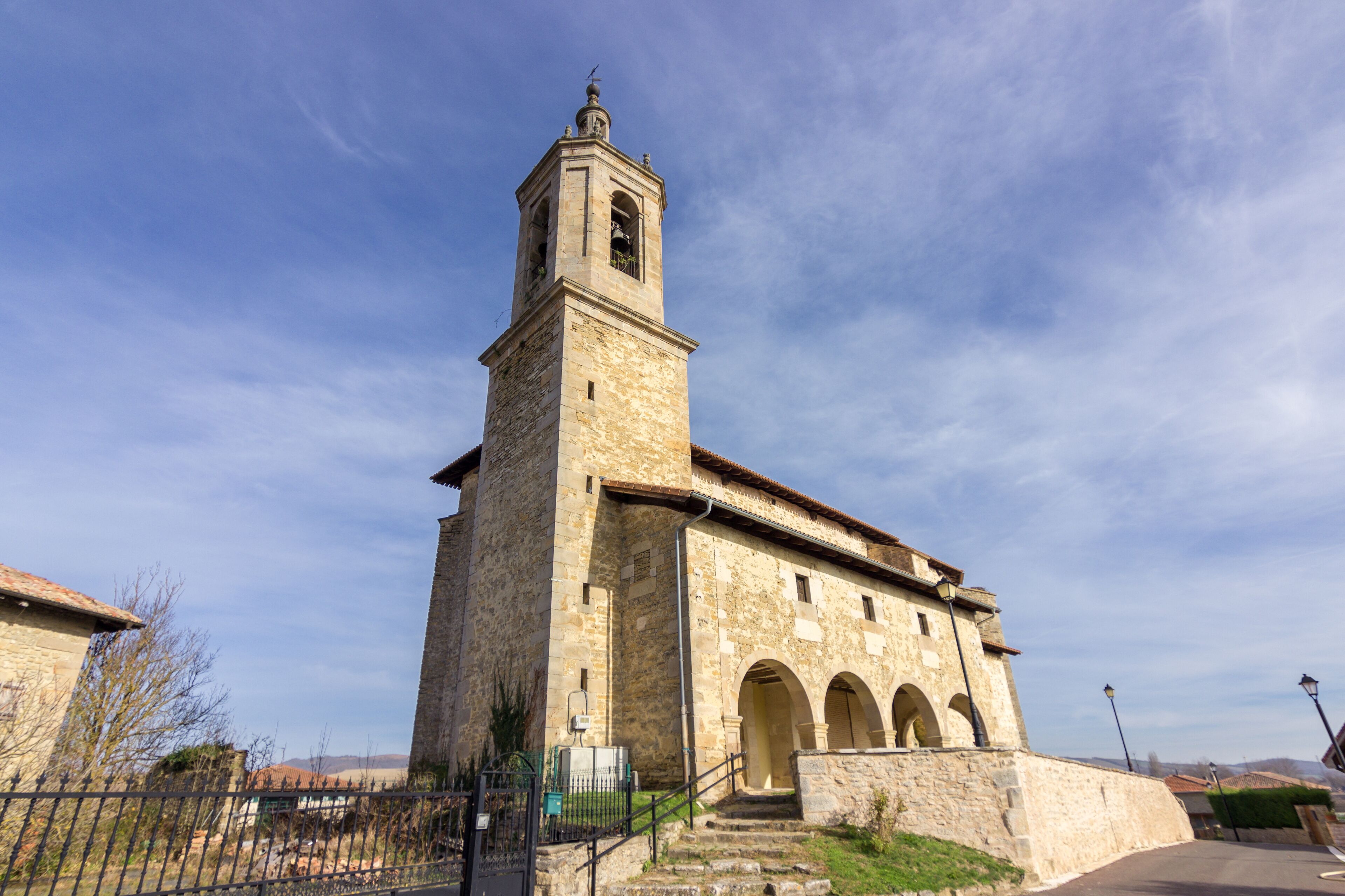 A historic stone church with a bell tower and arched windows.