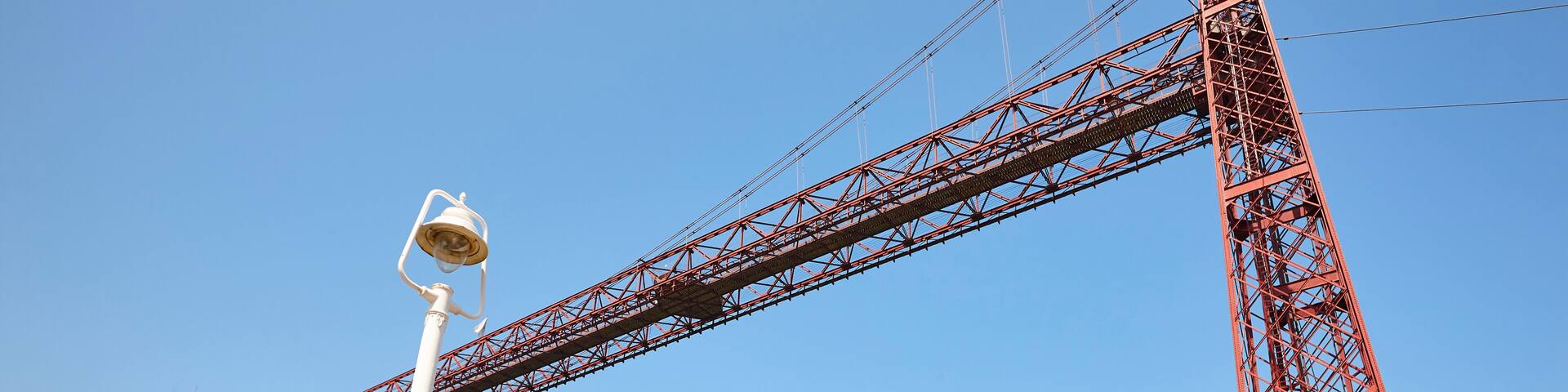 Bizkaia red iron hanging bridge and Nervion river. Euskadi