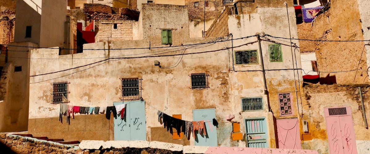A densely packed urban area with multi-story buildings, some with colorful doors and windows, and clothes hanging on lines.