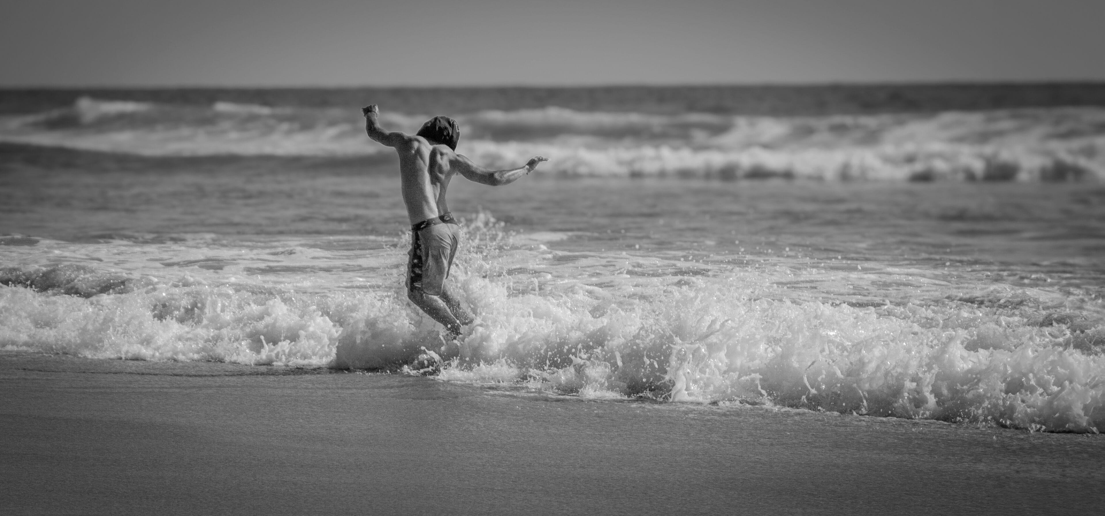 A person surfing on a beach with waves.