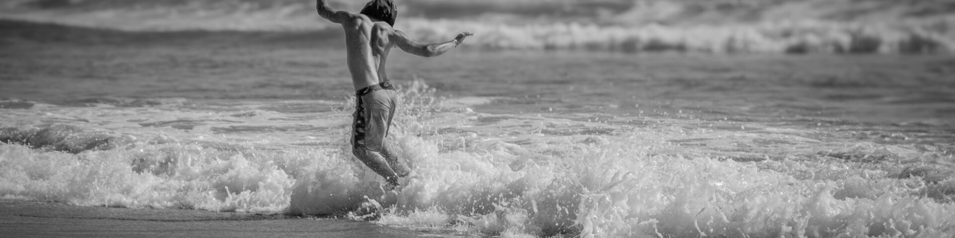A person surfing on a beach with waves.