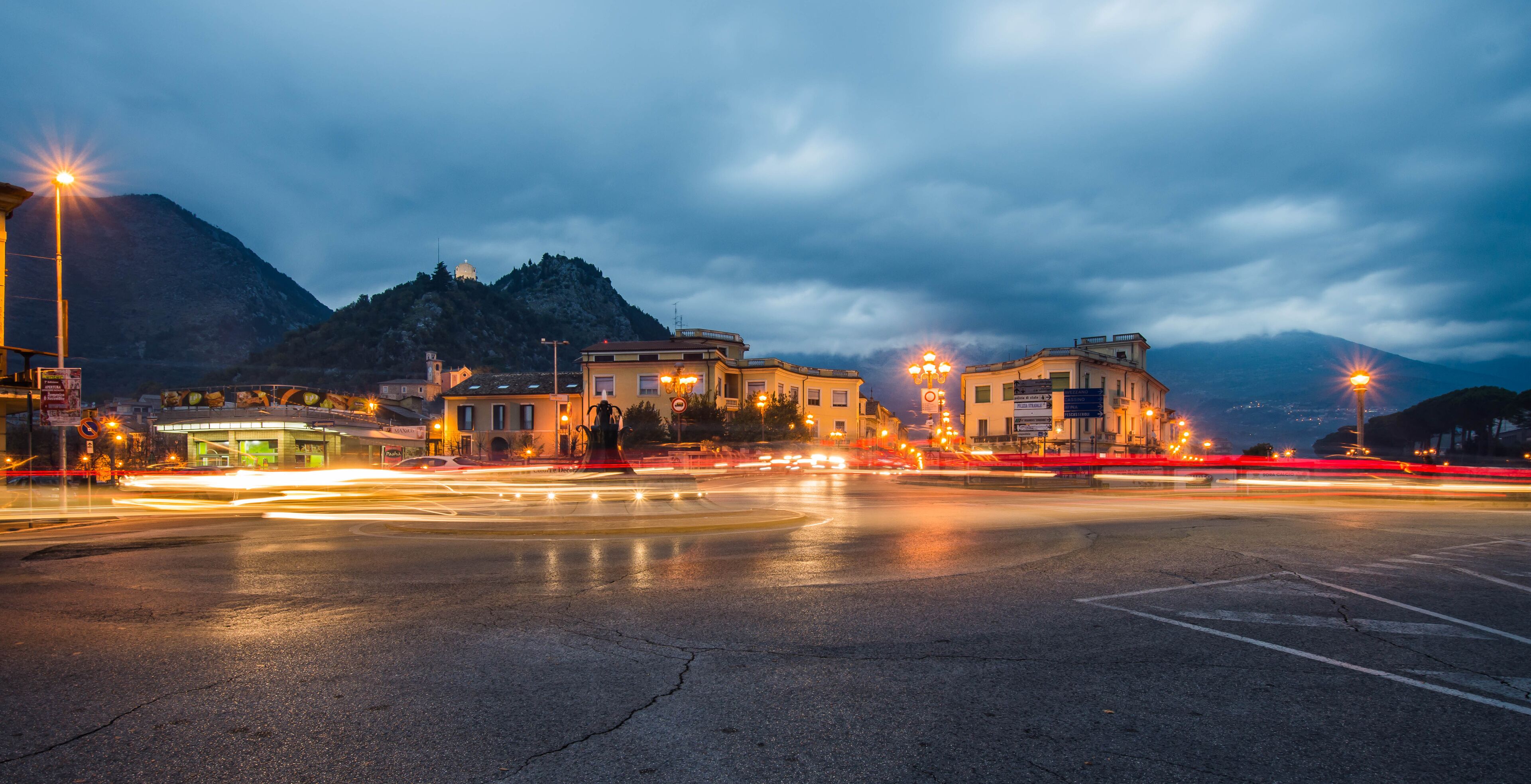 A nighttime cityscape with a mountain in the background.
