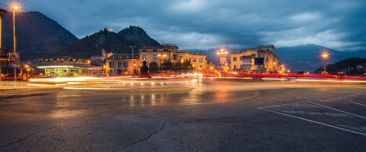 A nighttime cityscape with a mountain in the background.