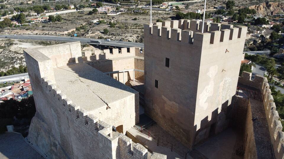 A large medieval castle with a prominent tower and surrounding walls.