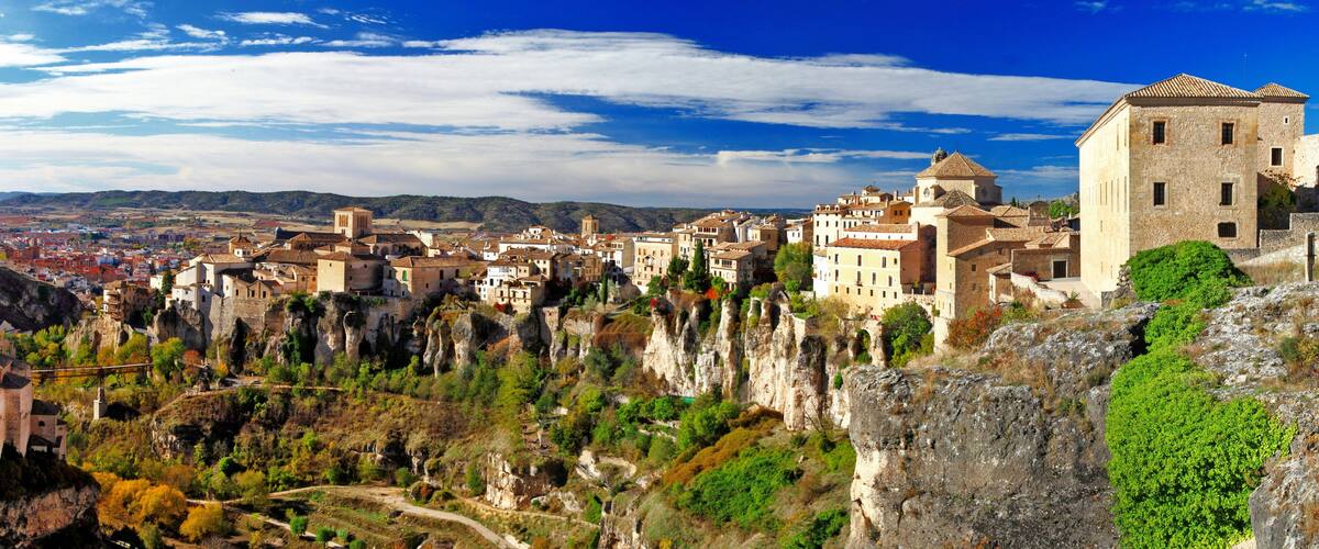 A town built on rocky cliffs with historic buildings and a clear blue sky.