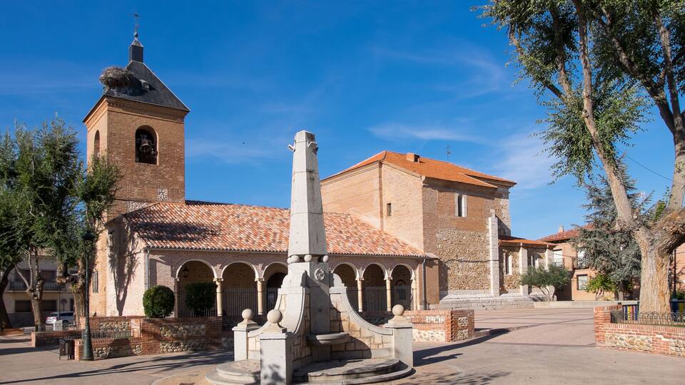 A historic building with a bell tower and a courtyard with a fountain.