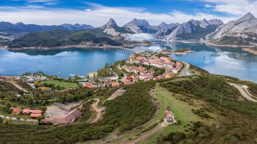 En kuststad med en bro över en lugn vik, omgiven av berg.