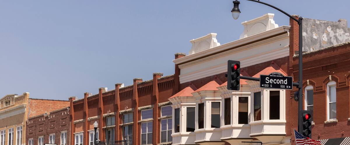 A street corner with historic buildings, a traffic light, and a 'Second' street sign.