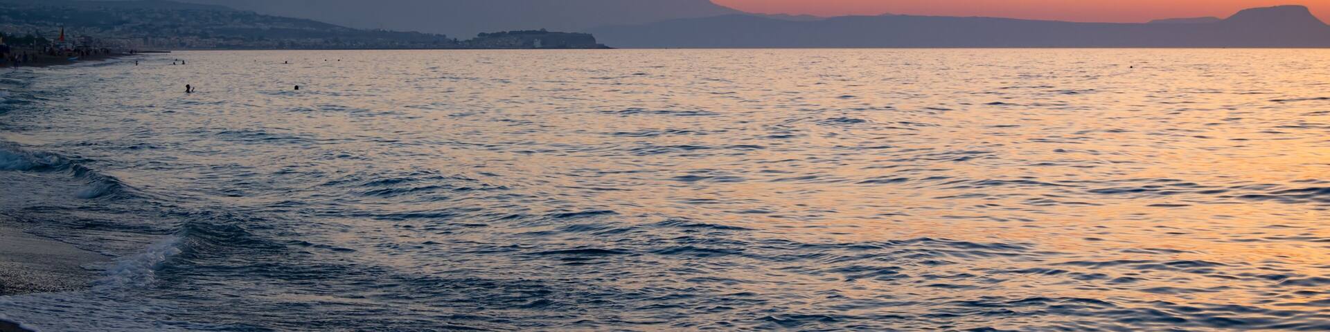 Sunset in the beach of Aegeian sea in Adelianos Kampos resort, Crete island, Greece