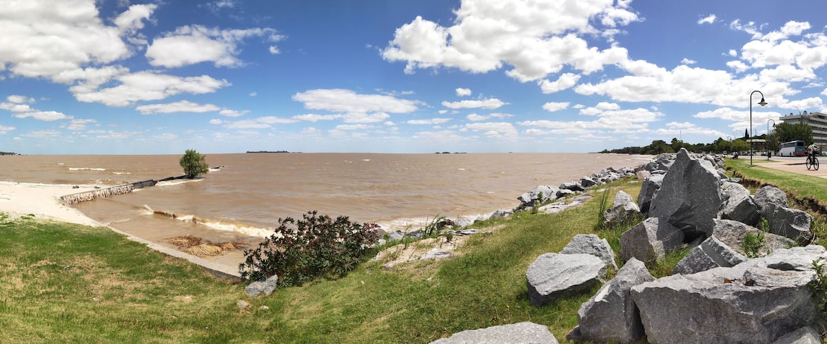A river with a rocky embankment and a grassy area.