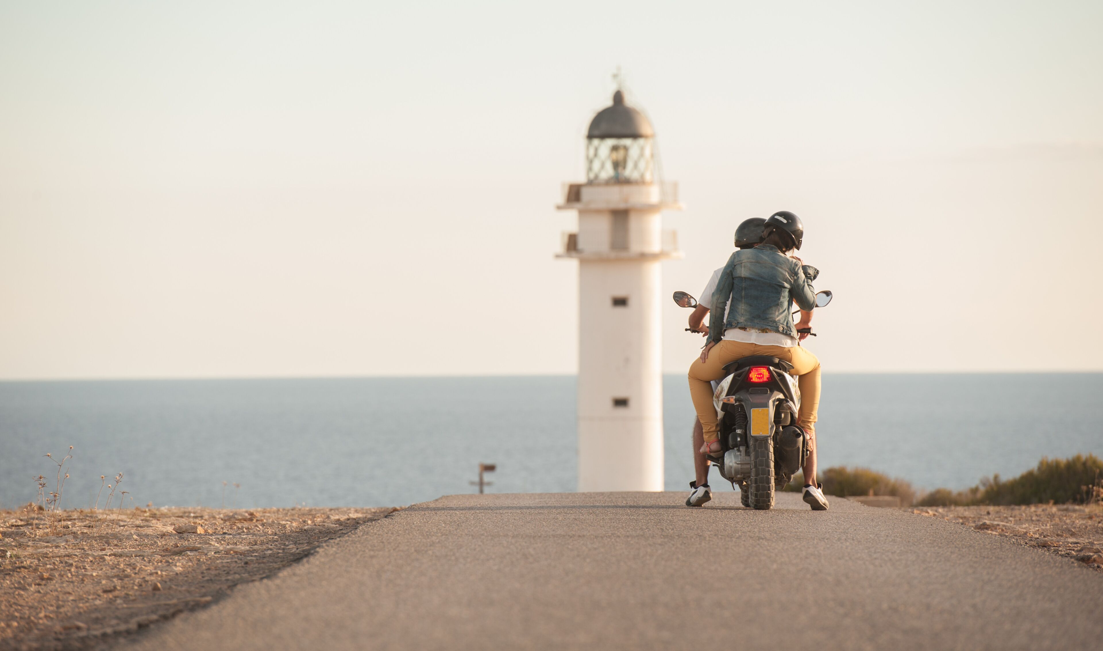 A road leading to a lighthouse by the sea.