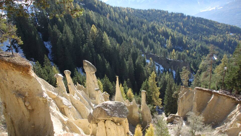 A rugged landscape with unique rock formations and dense forest.