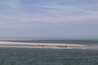Ein Strand mit Wellen und sandigem Ufer.