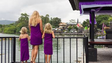 Happy family in Batur volcano hot spring spa. Travel in Kintamani, Bali. Mother, kids look at volcanic lake. Healthy lifestyle, recreational activity on summer holiday with children