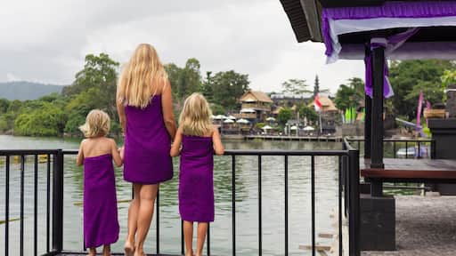 Happy family in Batur volcano hot spring spa. Travel in Kintamani, Bali. Mother, kids look at volcanic lake. Healthy lifestyle, recreational activity on summer holiday with children