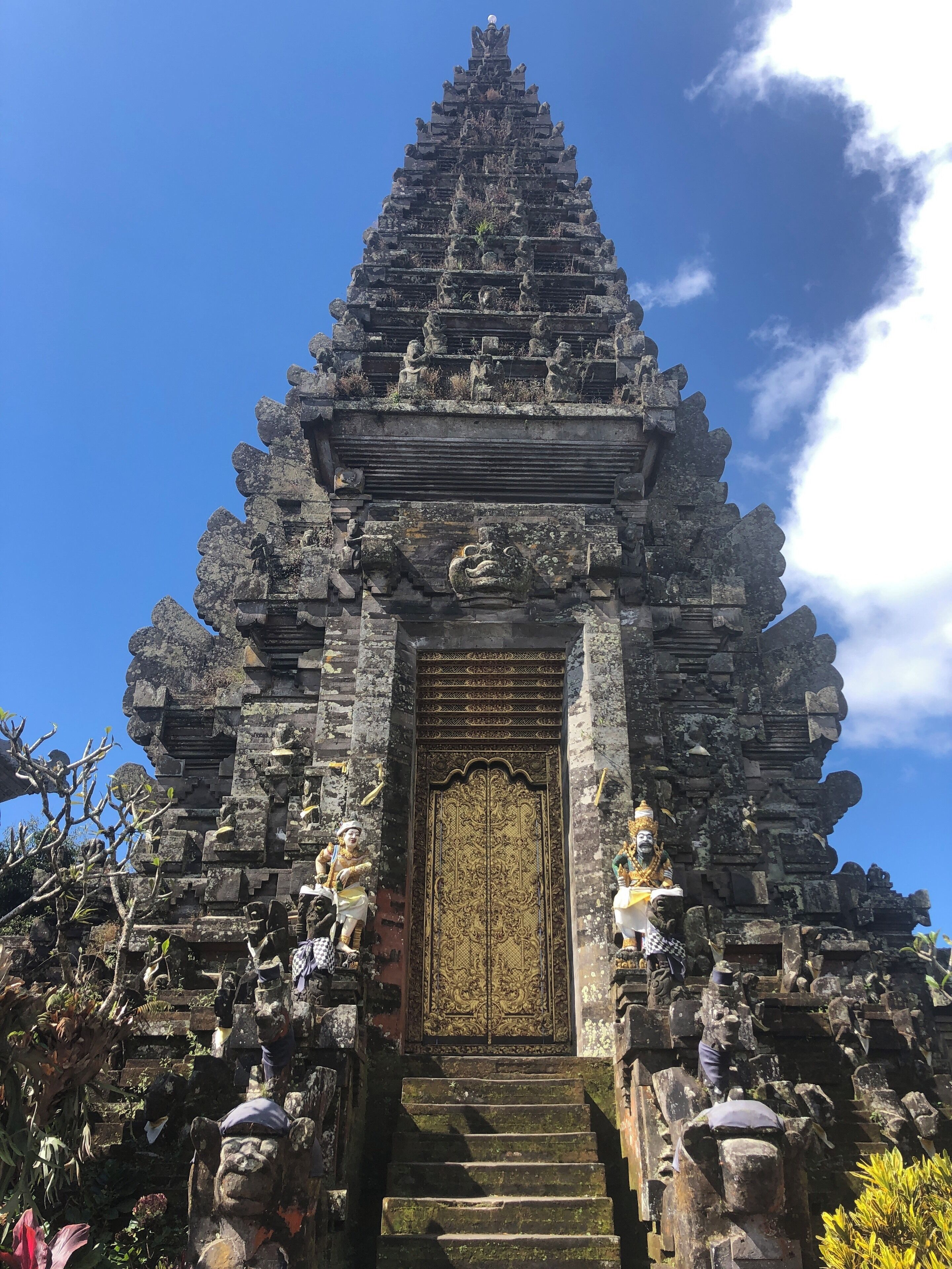 Un tempio con una porta dorata, statue in pietra e decorazioni elaborate.