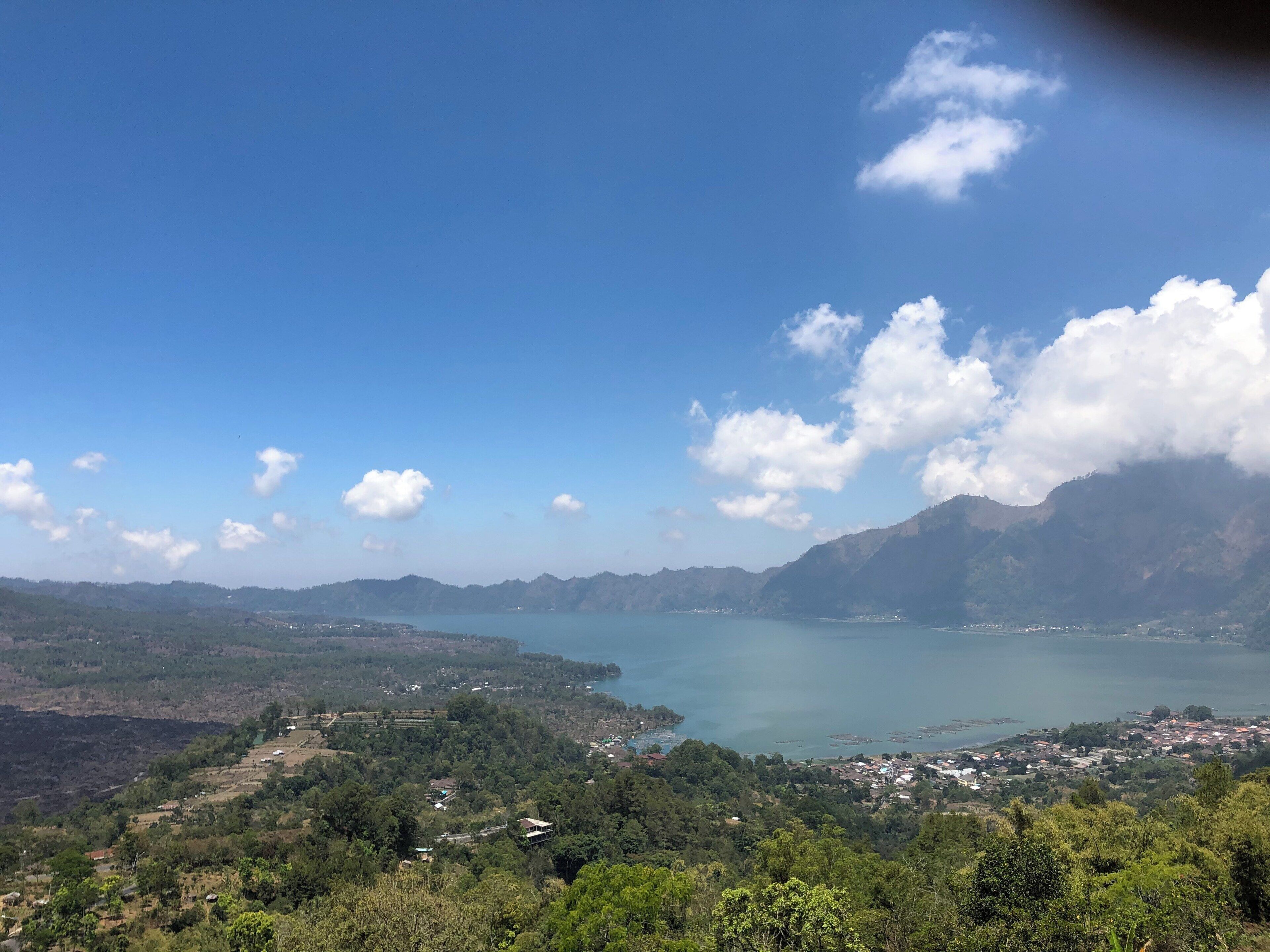 A mountainous landscape with a lake and scattered buildings.